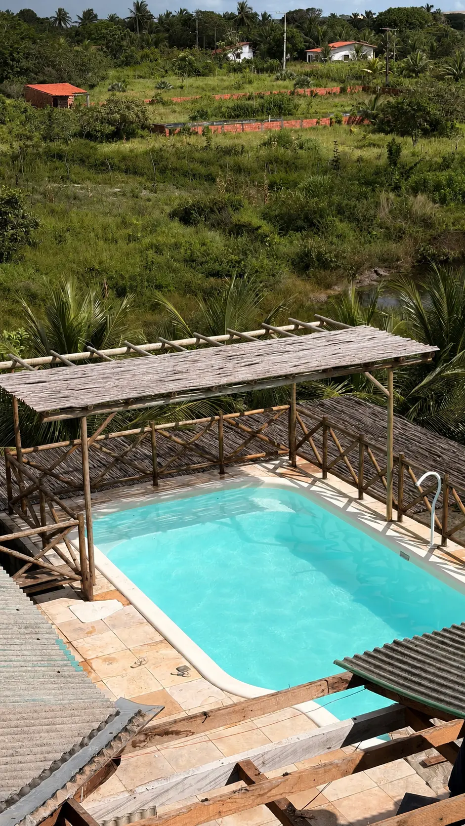 Vista aérea da piscina com pergolado de madeira
